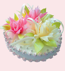 Праздничный торт круглый, украшен цветами, по форме напоминающими бутоны пиона.