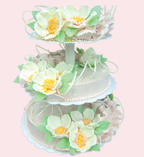Трехъярусный свадебный торт, украшенный огромными белыми цветами из глазури