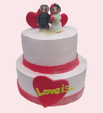 Свадебный торт: двухъярусный, украшен сливками и фигурками жениха и невесты.