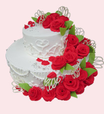 Торт двухъярусный, украшен розочками, расположенными каскадом на белоснежной основе из сливок.